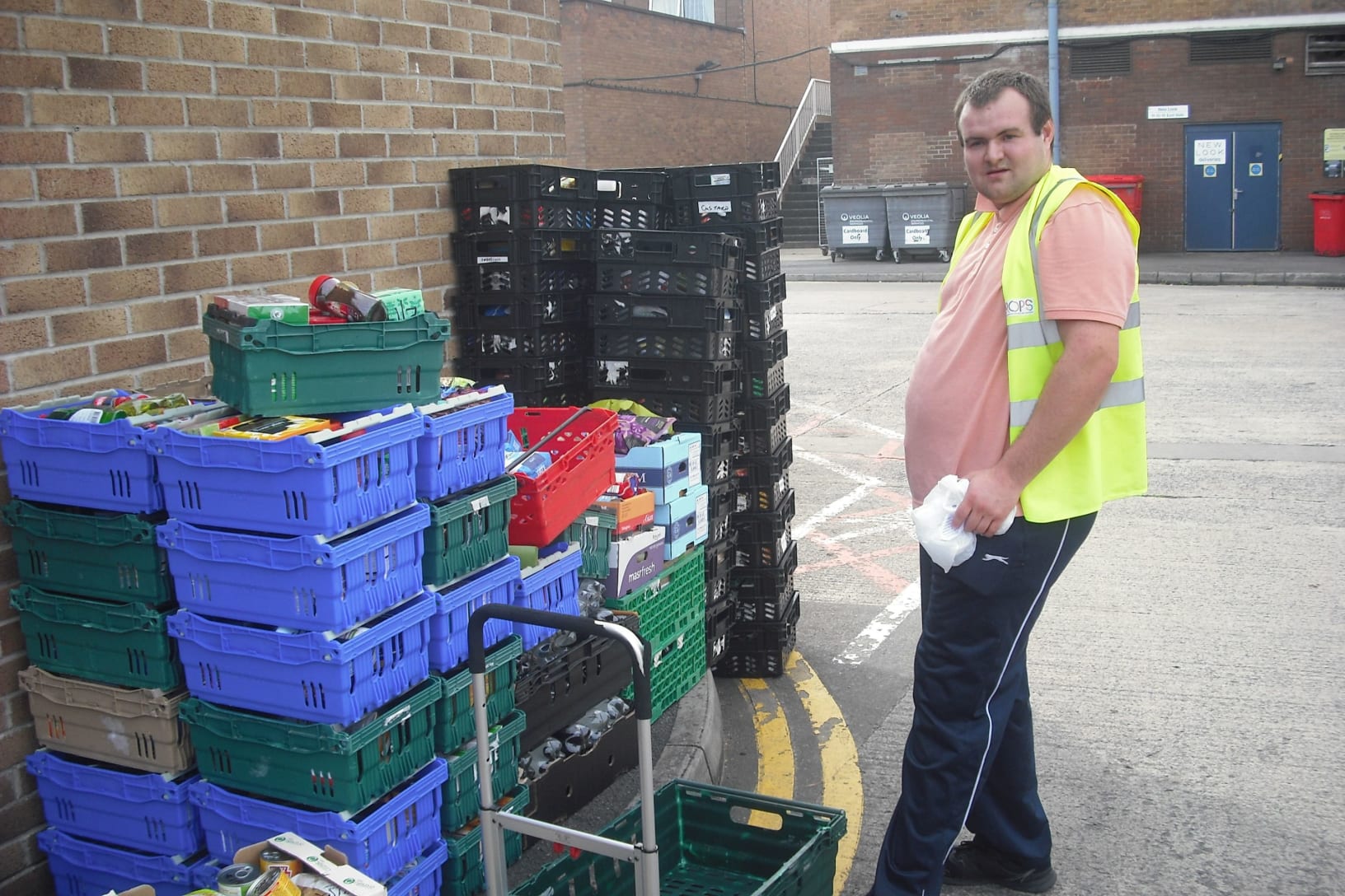 Trainee working at a foodbank, loading up boxes of donated goods